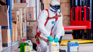A man in white lab suit handling chemicals