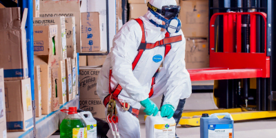 A man in white lab suit handling chemicals
